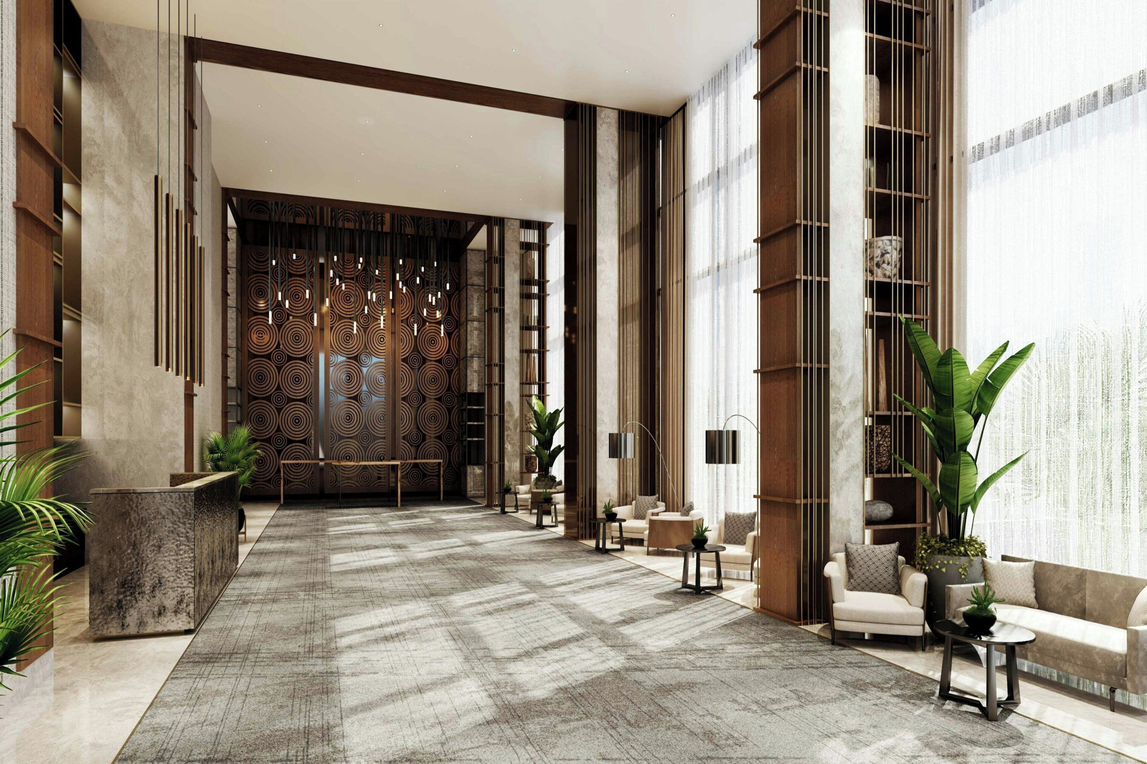 A spacious lobby with a patterned floor, seating areas, and large windows.