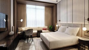 A modern hotel room with a large bed, a sofa, a desk, and a TV. - Kampala Marriott Hotel (Kampala)