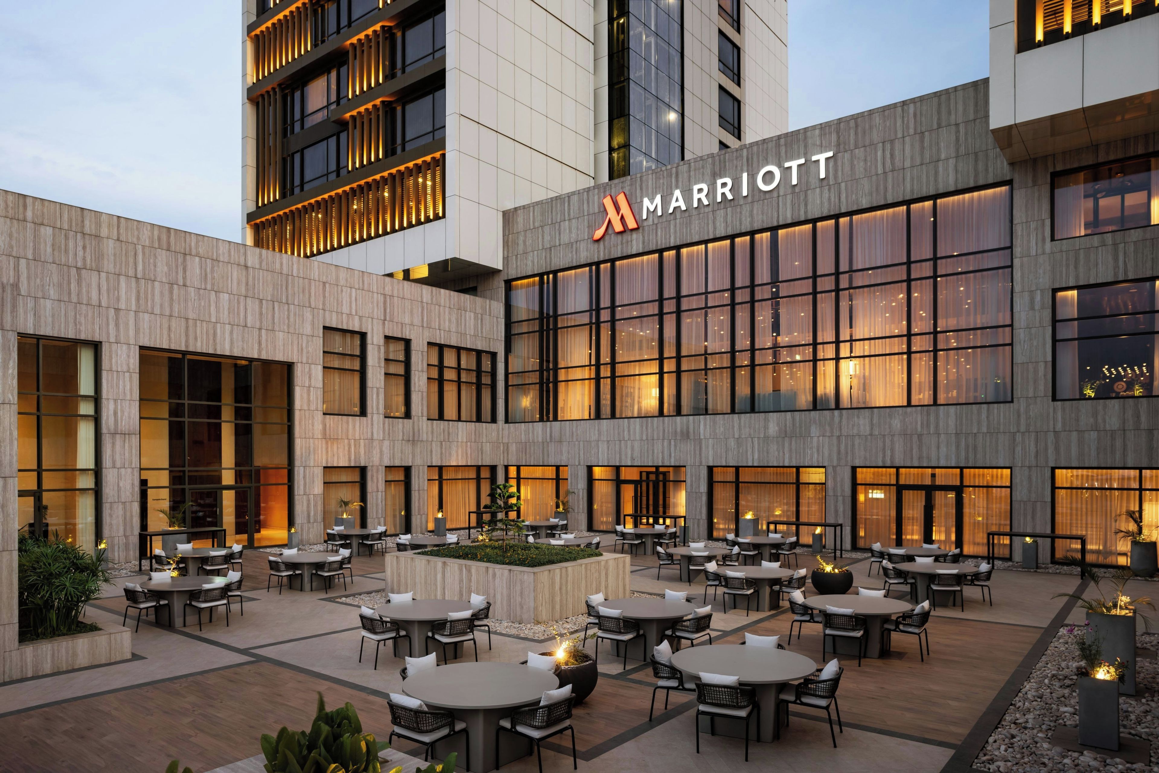 A Marriott hotel courtyard with outdoor seating and a modern building facade.