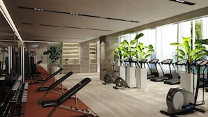 A modern gym with cardio machines, weight benches, and large windows allowing natural light. - Kampala Marriott Hotel (Kampala)