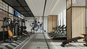 Un gimnasio con equipo de ejercicio, cintas de correr y un mural de atletas.