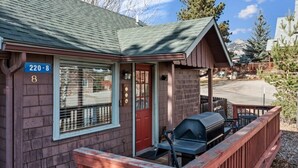 Eine kleine Holzhütte mit Veranda, Grill und Hinweisschild mit der Standortnummer.
