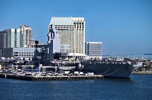 Un grand navire de guerre était amarré dans un port, avec une vue sur la ville en arrière-plan.