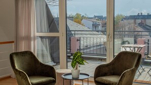 A room with two green velvet armchairs, a small round table, and a potted plant. - Penthouse maisonette apartment - Worms city center (Worms)