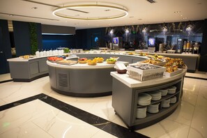 A modern buffet setup with various food items and a self-service station. - plaza hotel taksim (İstanbul)
