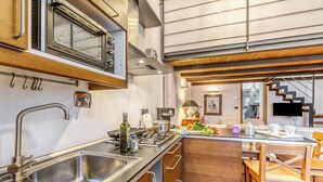 Una cocina moderna con electrodomésticos de acero inoxidable, armarios de madera y un comedor con sillas de madera.