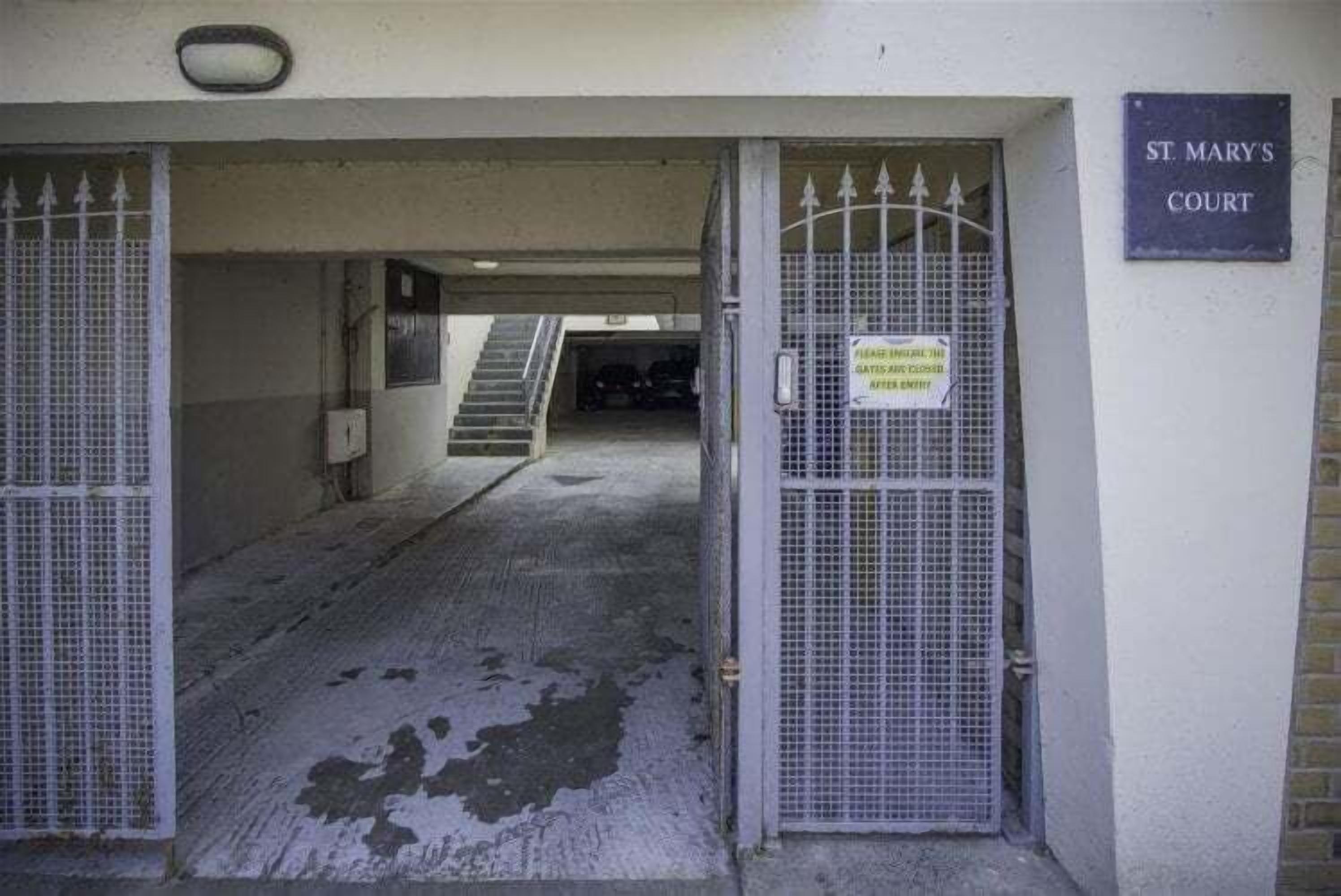 A gated entrance to St. Mary's Court with a staircase leading inside.