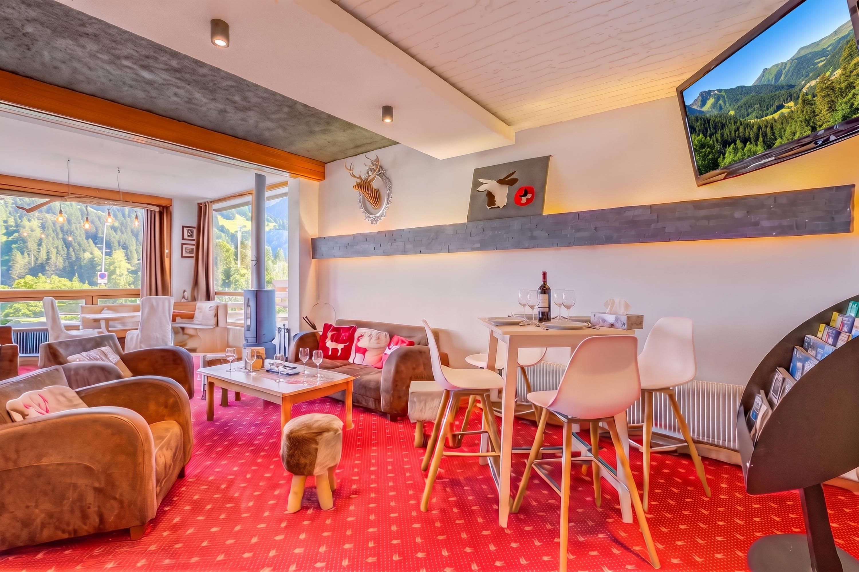 Un salon moderne avec une cheminée, un coin salon et une table à manger agrémentée de verres à vin.