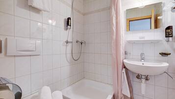 Une salle de bain moderne avec une baignoire, une douche et un lavabo.