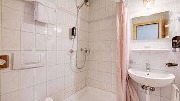 Ein Badezimmer mit Dusche, Badewanne, Waschbecken und Spiegel.