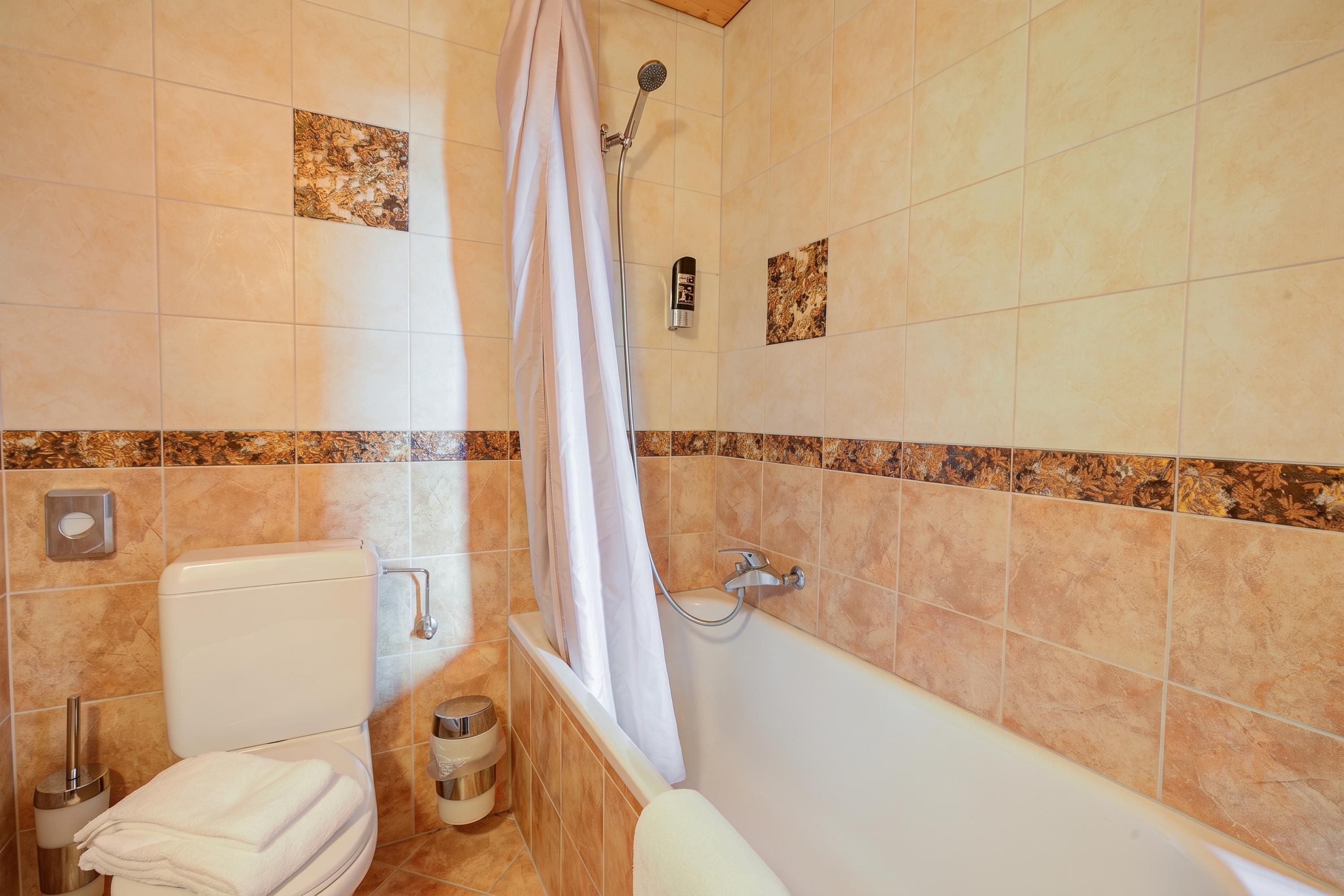 A bathroom with a toilet, bidet, and bathtub.