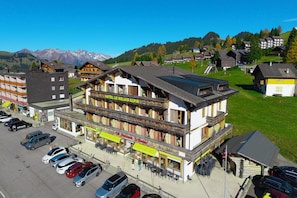 Un hotel con balcón, mobiliario exterior y vistas a las montañas.