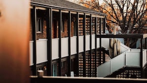 A modern building with a brick facade, multiple windows, and a staircase leading to an upper level. - La Vista Motel (Denver)