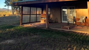 A single-story house with a covered patio, a wooden deck, and a large sliding glass door. - Charming 1-Bedroom In Cozy, Rural Hesperus - Perfect For A Quiet Getaway (Hesperus)