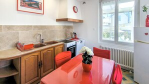 A kitchen with wooden cabinets, a sink, a stove, and a window with a view of the outside.