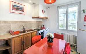 A kitchen with wooden cabinets, a sink, a stove, and a window with a view of the outside. - 2 bedroom gorgeous home in Vendôme (Vendôme)