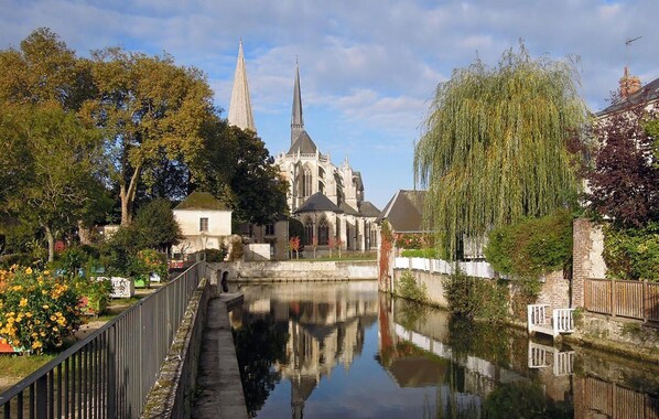 Un canal con una iglesia y un sauce llorón al frente.