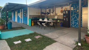 A covered outdoor area with a table and chairs, a refrigerator, and various kitchen utensils. - 3-bedroom house in PLAYA LAS HOJAS , SAN PEDRO ,MASAHUAT DPT LA PAZ. (san pedro masahuat)