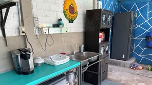 A kitchenette with a coffee maker, sink, and storage cabinets. - 3-bedroom house in PLAYA LAS HOJAS , SAN PEDRO ,MASAHUAT DPT LA PAZ. (san pedro masahuat)