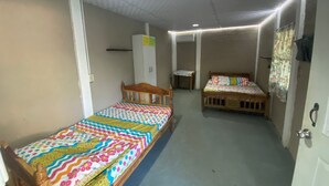 A room with two single beds, a wooden chair, a small table, and a wardrobe. - 3-bedroom house in PLAYA LAS HOJAS , SAN PEDRO ,MASAHUAT DPT LA PAZ. (san pedro masahuat)