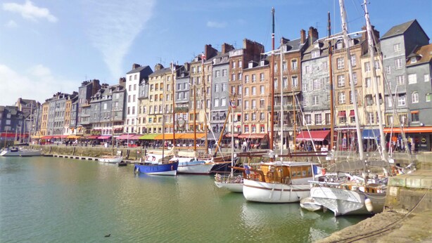 Una passeggiata sul lungomare con edifici storici e barche ormeggiate.