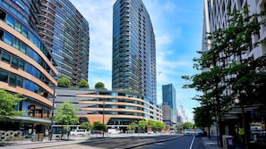 A modern urban street with high-rise buildings, a tram line, and a pedestrian walkway. - Sage Zen Muse Docklands Retreat (Docklands)