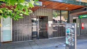 Fachada de un edificio moderno con una reja metálica, un cartel de la estación St Kilda y un letrero de estación de metro.