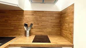 Une cuisine dotée de meubles en bois, d’un four encastré et d’une plaque de cuisson.
