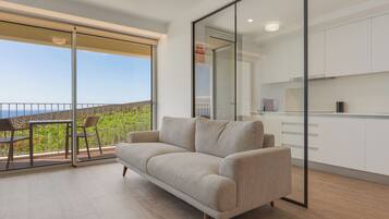 Departamento Deluxe, vista al mar | Área de sala de estar | Televisión de pantalla plana de 35 pulgadas con canales por cable