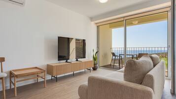 Departamento Deluxe, vista al mar | Área de sala de estar | Televisión de pantalla plana de 35 pulgadas con canales por cable