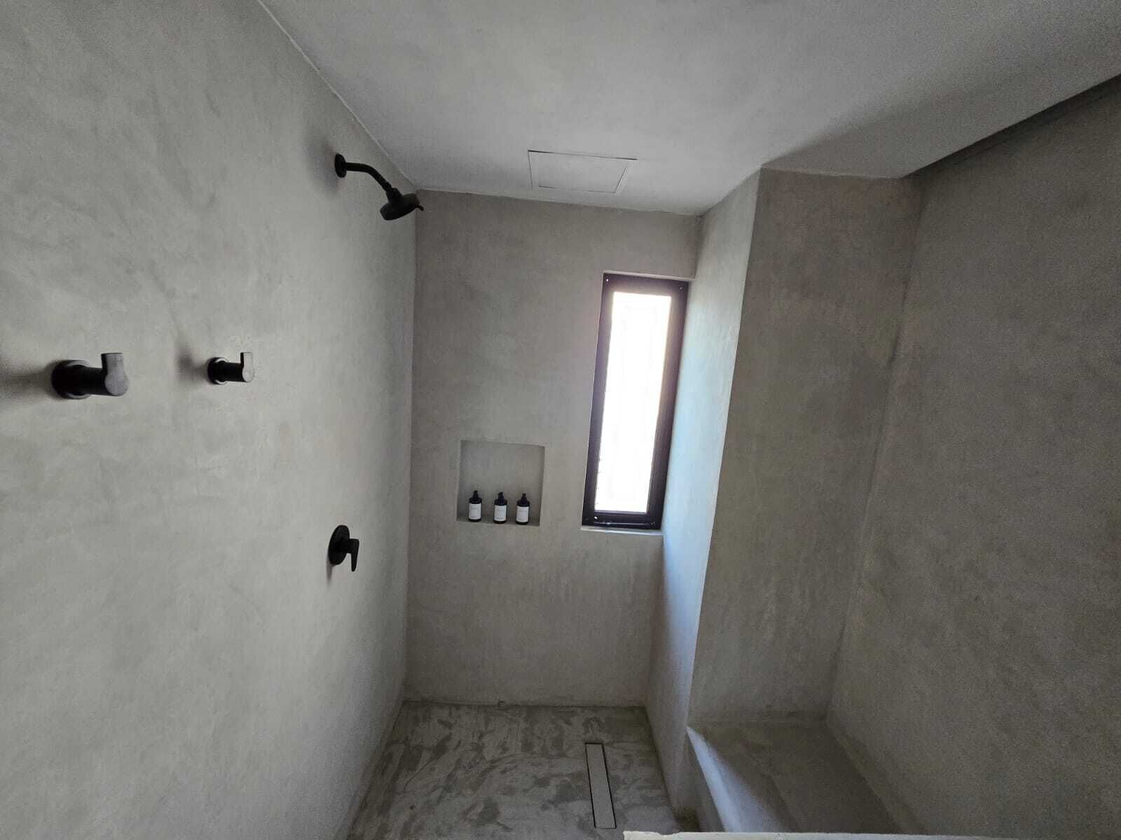 A bathroom with a shower, a window, and a wall-mounted medicine cabinet.