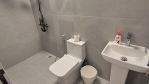 Et badeværelse med toilet, bidet og vask.