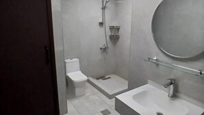 A modern bathroom with a toilet, shower, and two sinks. - Bombay Backpackers DXB Airport (Dubai)