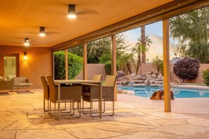 An outdoor patio with a dining table and chairs, a swimming pool, and a view of the surrounding landscape. - Scottsdale Clubhouse With Pool and Basketball (Scottsdale)