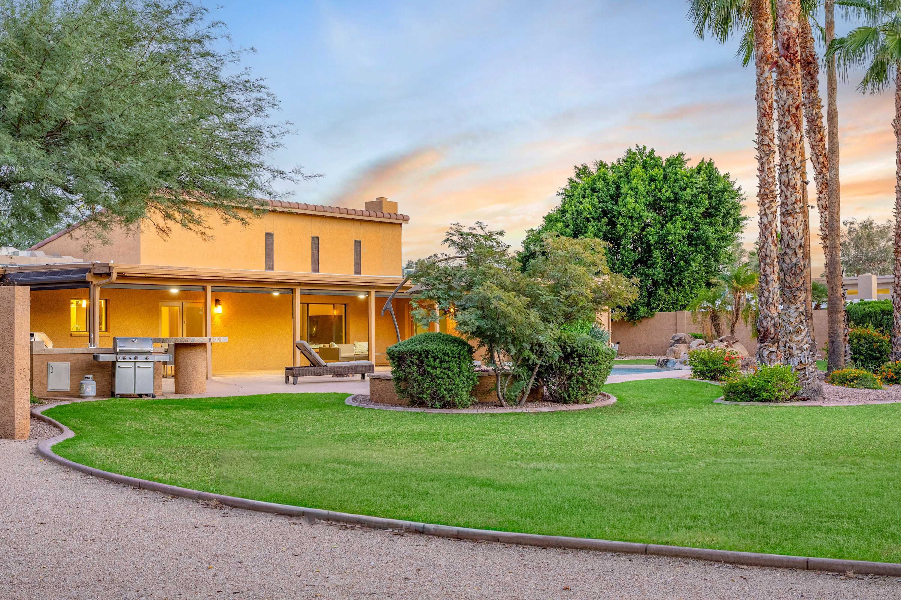 Een woonhuis met terras, buitenmeubilair en een verzorgd gazon.