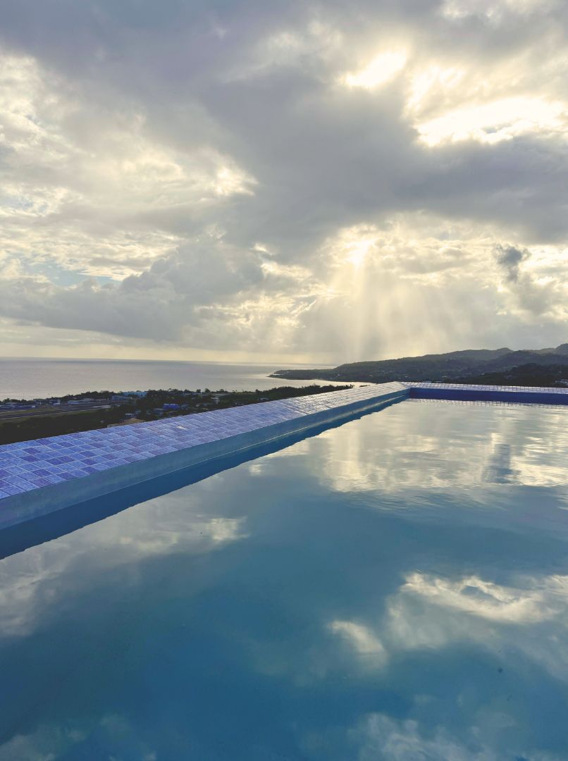 Uma piscina longa com vista ampla para o céu e paisagem distante.