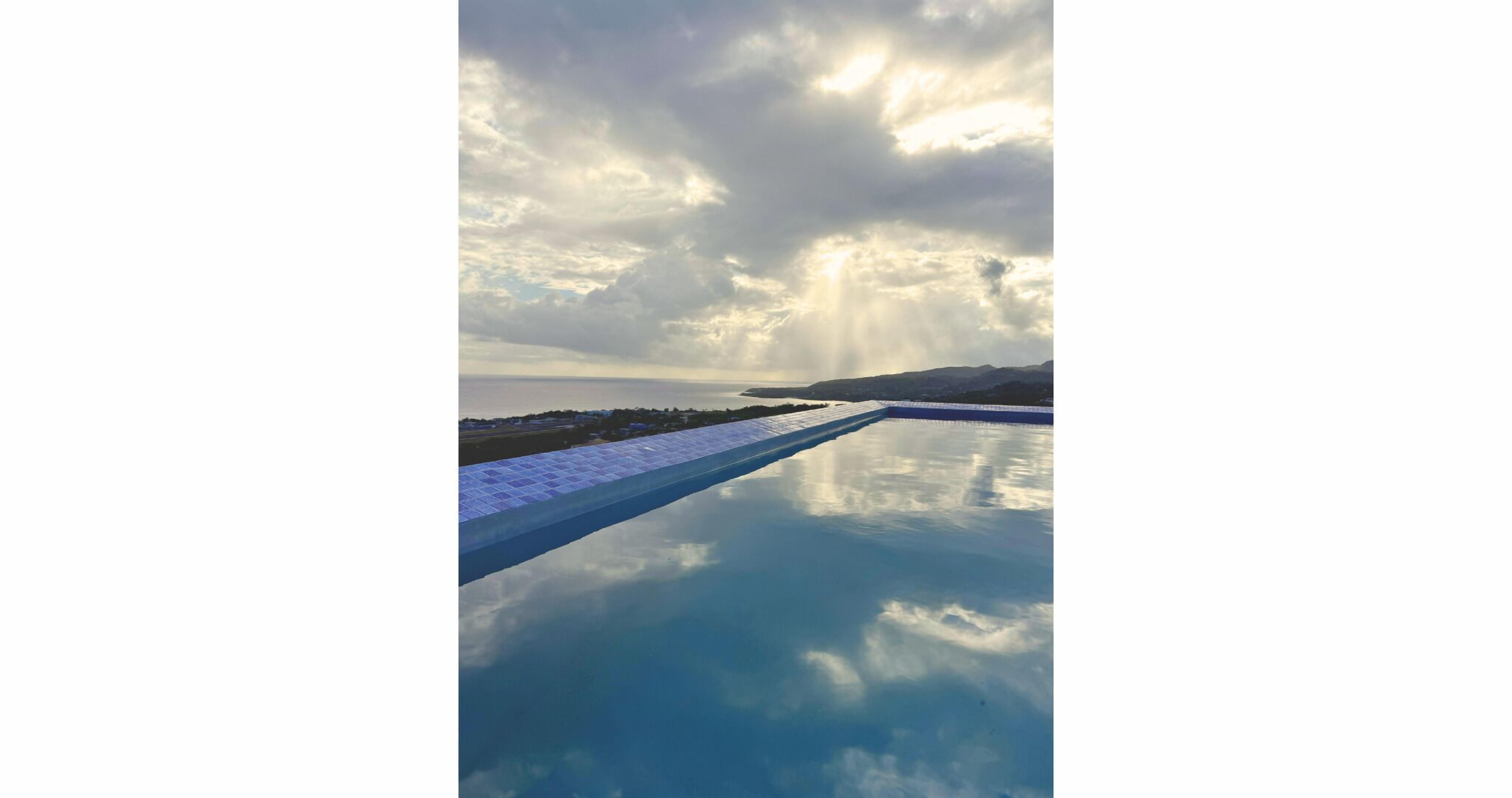 A long swimming pool with a clear view of the sky and distant landscape.