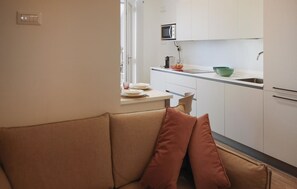 Eine Küchenzeile mit einer Mikrowelle, einem Spülbecken und einem Fenster.