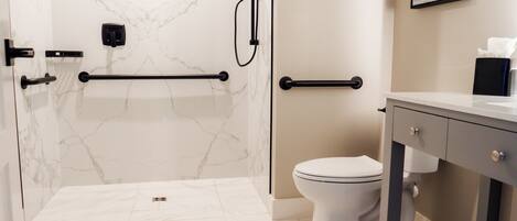 A bathroom with a shower, toilet, and vanity.