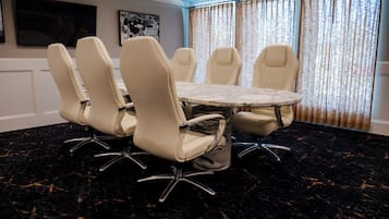 Uma sala de conferências com uma mesa de mármore e seis cadeiras com pés de metal.