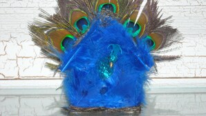 Un tocado con forma de pavo real, con plumas azules y verdes.