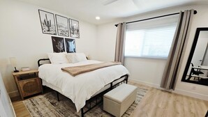 A bedroom with a bed, bedside tables, a nightstand, a bench, a rug, and a window with curtains. - Osborn Oasis - Half a Mile to old Town and Hospital (Scottsdale)