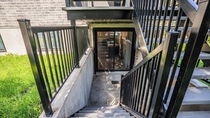 A set of outdoor stairs with metal railings leading to a building entrance. - 1756 Rue Balmoral | 3BR / 1BA Modern City Retreat (Longueuil)