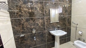 Un bagno con un lavandino bianco, uno specchio e un water.