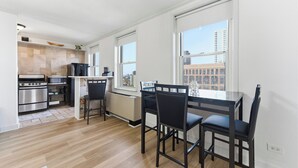 Une cuisine moderne avec un coin repas, de grandes fenêtres et une vue sur la ville.