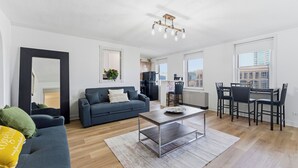 Un salon moderne avec un canapé, une table basse et un coin repas.