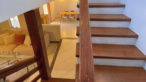 A wooden staircase leading to a dining area with a table and chairs. - Casa 5 Ruas com Hidro - Rio Tavares Florianopolis (Florianópolis)