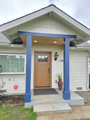A house with a brown front door, a blue porch, and a number '26' on the wall. - Relax and enjoy this stylish 3-bedroom, 2-bath retreat sleeps 8! (Vancouver)