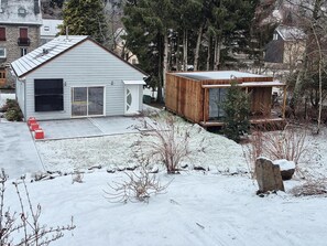 Ein modernes Haus mit großer Garage und einer Holzterrasse.