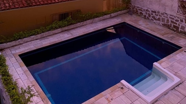 Une piscine offrant une vue sur le paysage urbain au coucher du soleil.